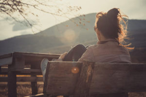 A woman sits alone while thinking. Trauma therapy in Grand Rapids, MI can offer support in overcoming trauma symptoms. Learn more about online trauma therapy in Kent County, MI by contacting an online trauma therapist in Grand Rapids, MI. 49505 | 49503 | 49507