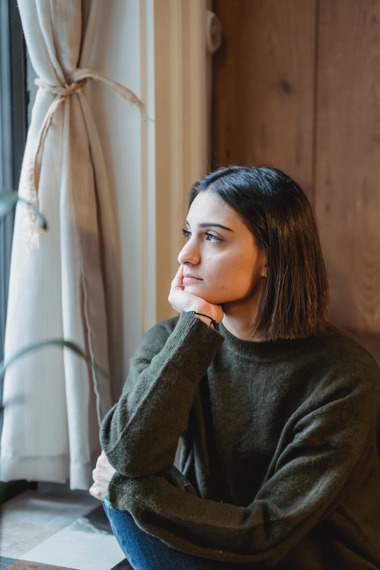 A woman rests her head against her hand while looking out hte window. Learn more about the support an anxiety therapist in Grand Rapids, MI can offer via depression treatment in Grand Rapids, MI. We offer depression treatment in Kent County, MI and other services.