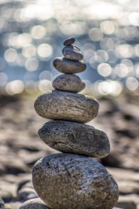 The image of balanced rocks represents the balance you can find in your mental health. Reach out today for mindfulness therapy in Michigan, near Alpina, MI and Grand Rapids.