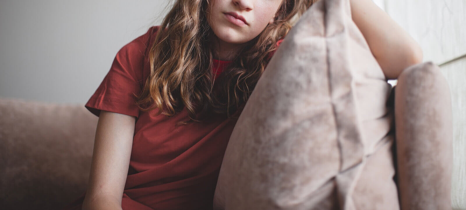 Shows a teen girl looking sad and thinking. Represents how teenage counseling in Grand Rapids, MI is a great resource for teens navigating their depression symptoms.