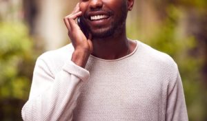 Shows a man on the phone and smiling. Symbolizes how a depression therapist in kent county, mi will support you through mindfulness to feel better.